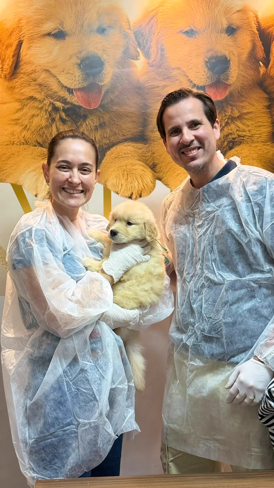 Casal segurando um filhote de Golden Retriever