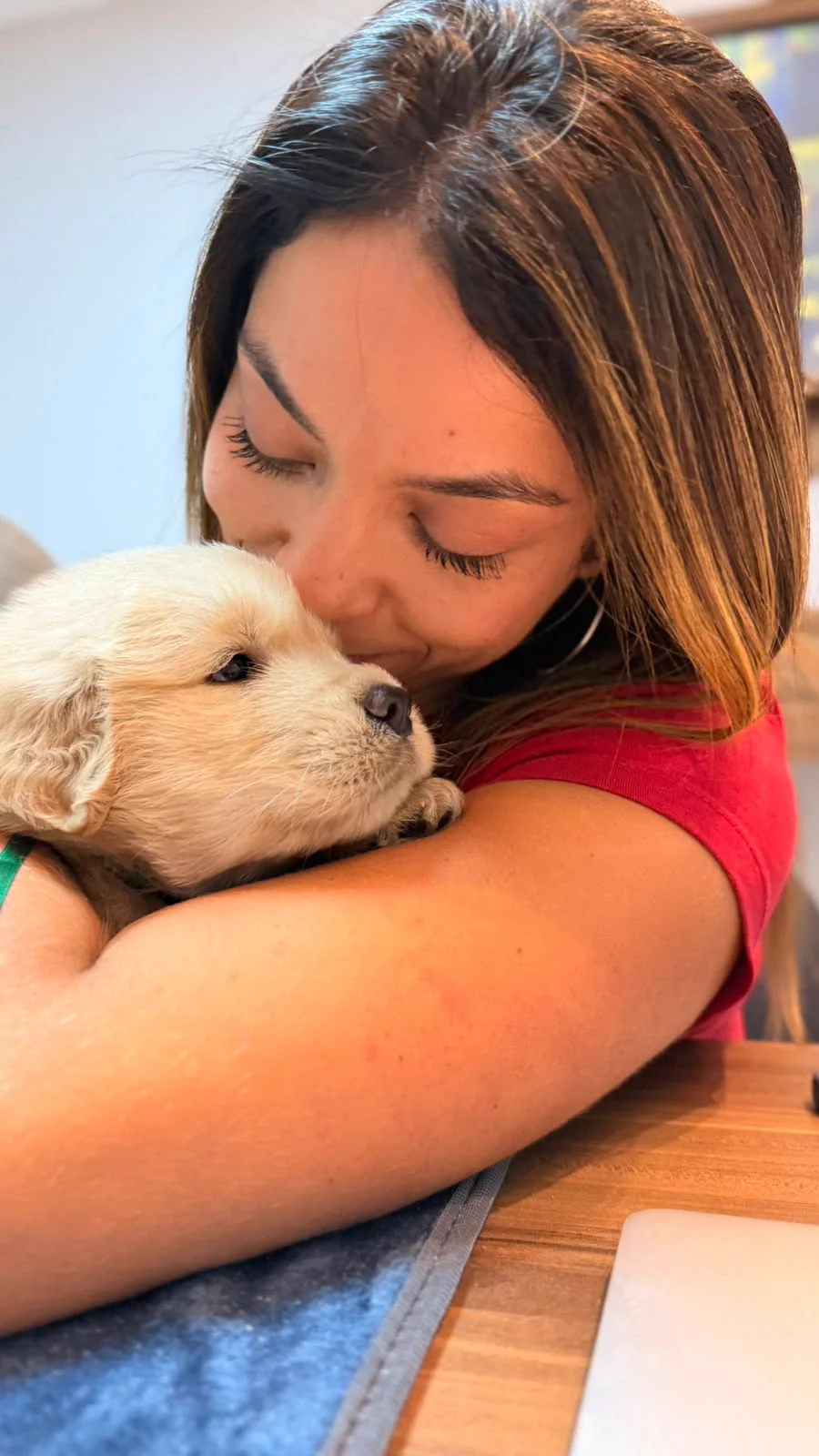 Jovem abraçando um filhote de Golden Retriever
