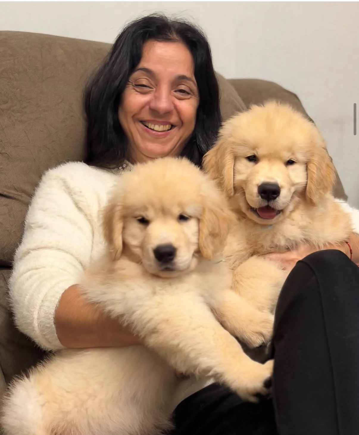 Mulher sorrindo com filhotes de Golden Retriever